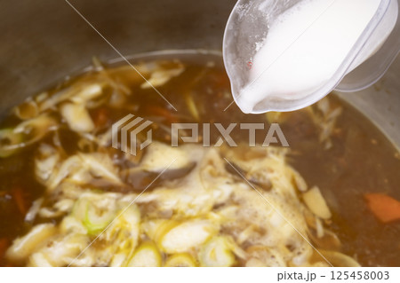 残り物のカレーで作ったカレーうどんを丼に盛り付ける 125458003