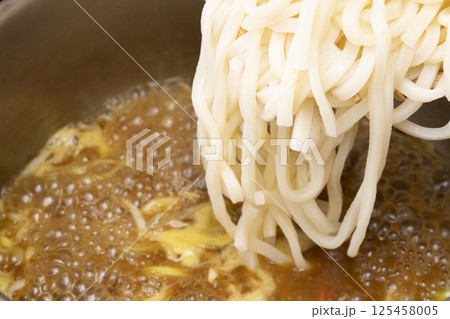 残り物のカレーで作ったカレーうどんを丼に盛り付ける 125458005
