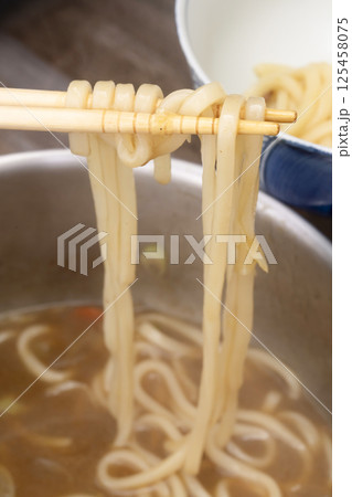 残り物のカレーで作ったカレーうどんを丼に盛り付ける 125458075