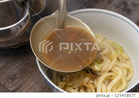 残り物のカレーで作ったカレーうどんを丼に盛り付ける 125458077