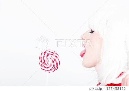 Woman with white wig and lollipop Woman with white wig and lollipop 125458122