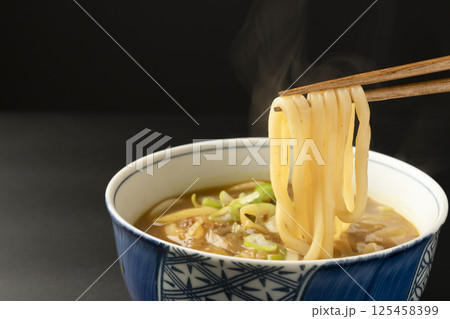 残り物のカレーで作ったカレーうどんを箸で持ち上げる 125458399