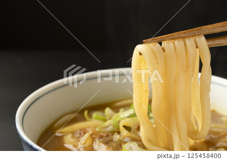 残り物のカレーで作ったカレーうどんを箸で持ち上げる 残り物のカレーで作ったカレーうどんを箸で持ち上げる 125458400