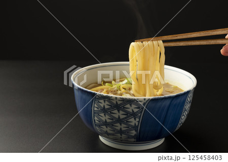 残り物のカレーで作ったカレーうどんを箸で持ち上げる 残り物のカレーで作ったカレーうどんを箸で持ち上げる 125458403