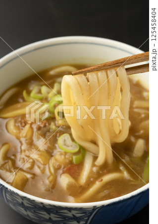 残り物のカレーで作ったカレーうどんを箸で持ち上げる 残り物のカレーで作ったカレーうどんを箸で持ち上げる 125458404