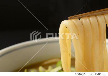 残り物のカレーで作ったカレーうどんを箸で持ち上げる 125458406