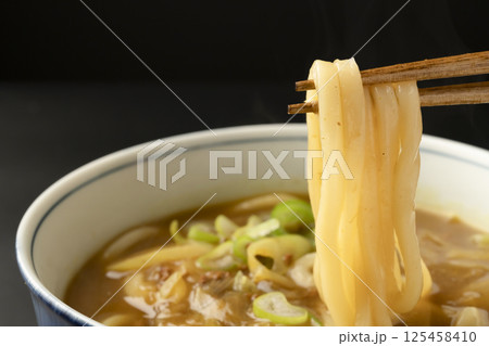 残り物のカレーで作ったカレーうどんを箸で持ち上げる 125458410