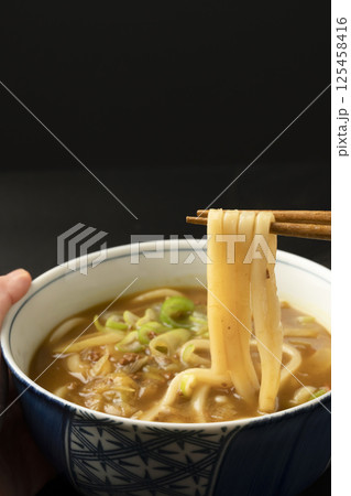 残り物のカレーで作ったカレーうどんを箸で持ち上げる 残り物のカレーで作ったカレーうどんを箸で持ち上げる 125458416