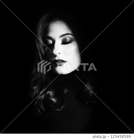 Beautiful woman portrait standing in darkness with illuminated face Beautiful woman portrait standing in darkness with illuminated face 125458589