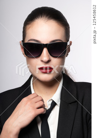 Woman portrait with black suit and sunglasses Woman portrait with black suit and sunglasses 125458612