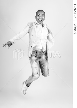 Happy Thai woman with suit and jeans jumping in air 125459251