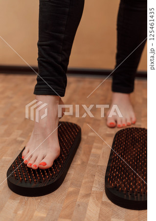 The woman put one foot on the sadhu's board. An attempt to stand on nails The woman put one foot on the sadhu's board. An attempt to stand on nails 125461435