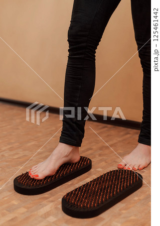 A woman tries to stand on the board of a sadhu. An attempt to stand on nails 125461442