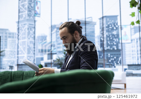 Young business director reviews sales trends and budget reports in his smart office, ensuring profitability and company success through effective decision making and strategic planning. Young business director reviews sales trends and budget reports in his smart office, ensuring profitability and company success through effective decision making and strategic planning. 125461972