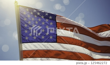 Close up of the American flag waving against a blue sky. Symbol of patriotism, independence, and national pride. Ideal for themes related to American culture, history, and values. Close up of the American flag waving against a blue sky. Symbol of patriotism, independence, and national pride. Ideal for themes related to American culture, history, and values. 125462272