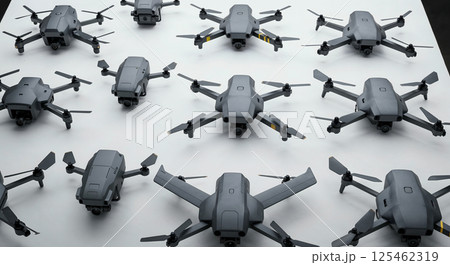 Several identical gray drones with folded and extended propellers arranged neatly on a surface, showcasing various angles and perspectives, highlighting modern technology 125462319