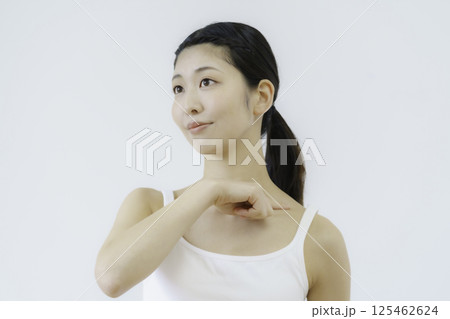 白背景の肩のツボを押す若い女性の顔のアップ 白背景の肩のツボを押す若い女性の顔のアップ 125462624