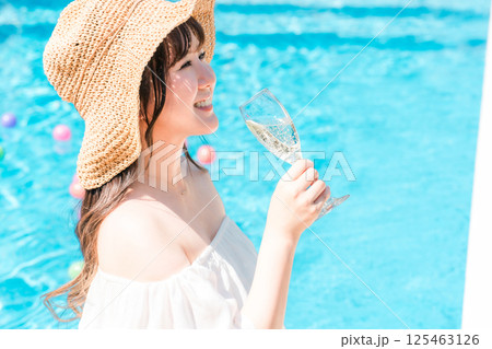 プールサイドでシャンパンを飲む若いアジア人女性（リゾート,バカンス,バケーション） 125463126