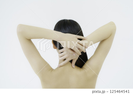 白背景のうなじを触る若い女性の後ろ姿 125464541