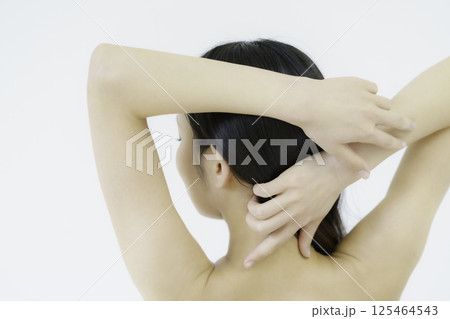 白背景のうなじを触る若い女性の後ろ姿 白背景のうなじを触る若い女性の後ろ姿 125464543