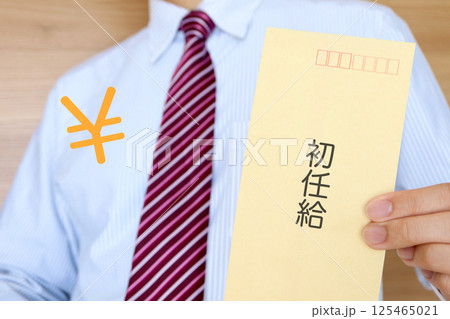 初任給の封筒を持つビジネスマン 初任給の封筒を持つビジネスマン 125465021