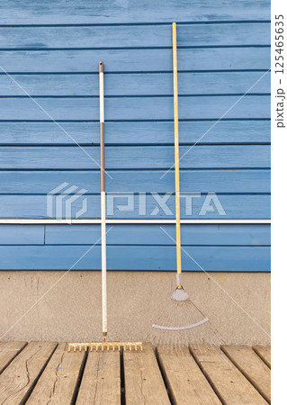 different garden rake near blue wooden wall 125465635