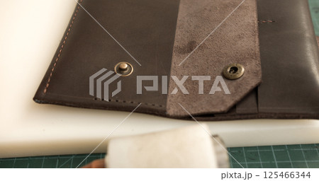 Close-up of handmade leather wallet with button flap Close-up of handmade leather wallet with button flap 125466344