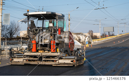 Modern asphalt paver machine working on city street 125466376