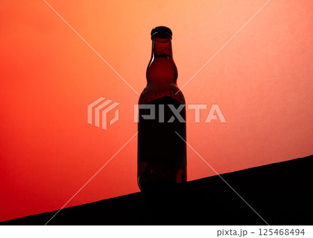 Backlit beer bottle mockup on red background with copy space 125468494