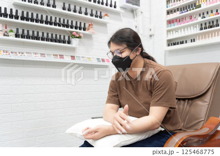 Woman (LGBTQ) do a manicure or pedicure at nails 125468775