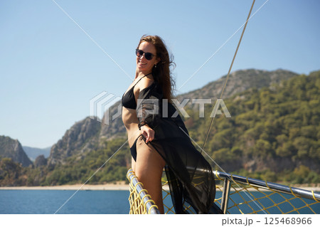 Happy woman on yacht enjoying sunny sea journey 125468966