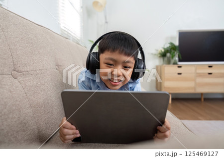 Back to School and Learning Fun. A young boy engaged with a tablet, excited about his educational content. Back to School and Learning Fun. A young boy engaged with a tablet, excited about his educational content. 125469127