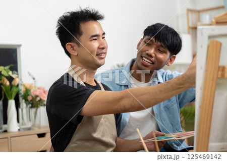 Couple and Artistic Collaboration. A gay couple painting together, showcasing their bond and creativity in a cozy setting. 125469142