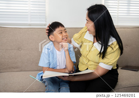 Back to School and Joyful Interactions. A mother and son enjoying a lighthearted moment while studying. 125469201