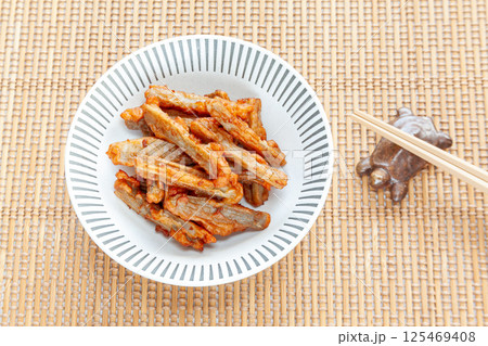 小鉢に盛った唐辛子入りゴボウのすり身揚げ 125469408