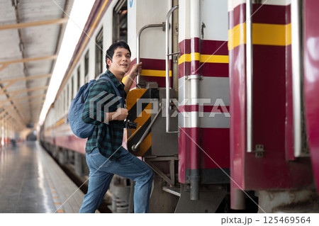 Journey and Adventure. A young traveler boards a train with a camera. Journey and Adventure. A young traveler boards a train with a camera. 125469564