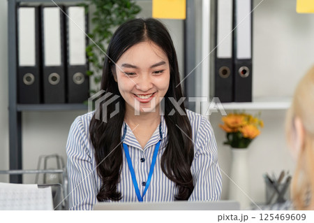 Business professional engaging in conversation with a colleague in a modern office 125469609
