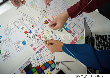 Team Coordination and Idea Exchange. Designers sharing layouts and feedback in an interactive session for UI design. Team Coordination and Idea Exchange. Designers sharing layouts and feedback in an interactive session for UI design. 125469758