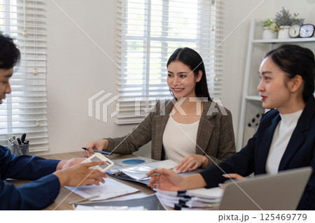 Professional collaboration. A woman engaging with tax data during a team discussion in a modern office environment. Professional collaboration. A woman engaging with tax data during a team discussion in a modern office environment. 125469779
