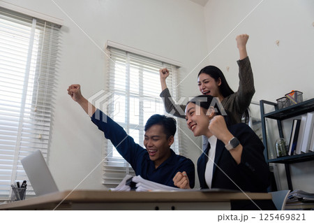 Excited team celebrating success in a modern office, showcasing teamwork and achievement. Excited team celebrating success in a modern office, showcasing teamwork and achievement. 125469821