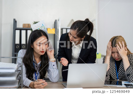 Team experiencing stress while analyzing financial data and discussing strategies in an office setting. Team experiencing stress while analyzing financial data and discussing strategies in an office setting. 125469849