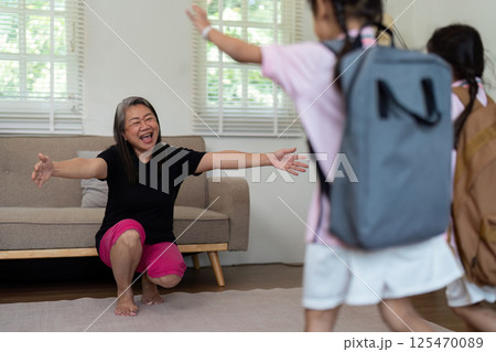 Joyful Reunion and Family Love. A mother welcomes her children home from school with open arms. 125470089