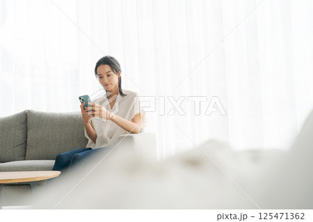 ソファに座ってくつろぐ女性 ソファに座ってくつろぐ女性 125471362