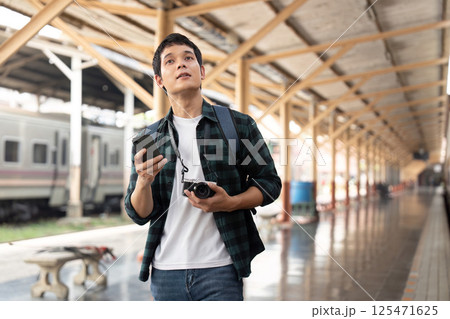 Exploration and Adventure. A traveler looks up at the train station while planning his next destination. 125471625