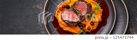 Sliced Venison Filet with Berry Garnish on Sweet Potato Puree 125471744
