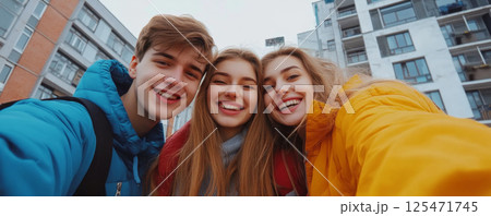 Smiling Friends Taking a Selfie Outdoors in Urban Setting 125471745