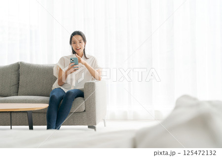 ソファに座ってくつろぐ女性 ソファに座ってくつろぐ女性 125472132