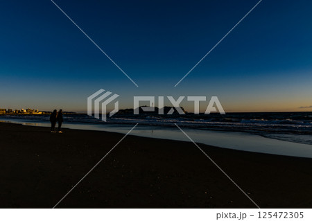 夕暮れ時の海岸で遊ぶ人々 夕暮れ時の海岸で遊ぶ人々 125472305