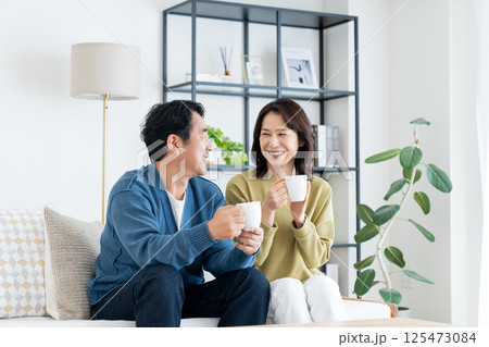 リビングでコーヒーを飲むミドルの夫婦 125473084
