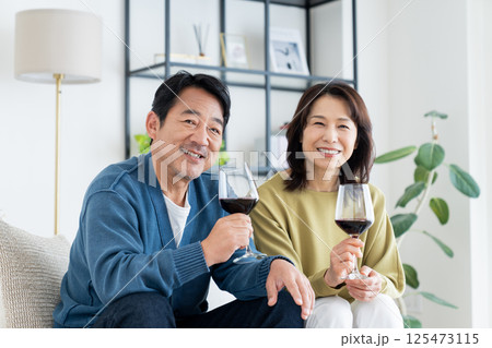 リビングでワインを飲むミドルの夫婦 125473115